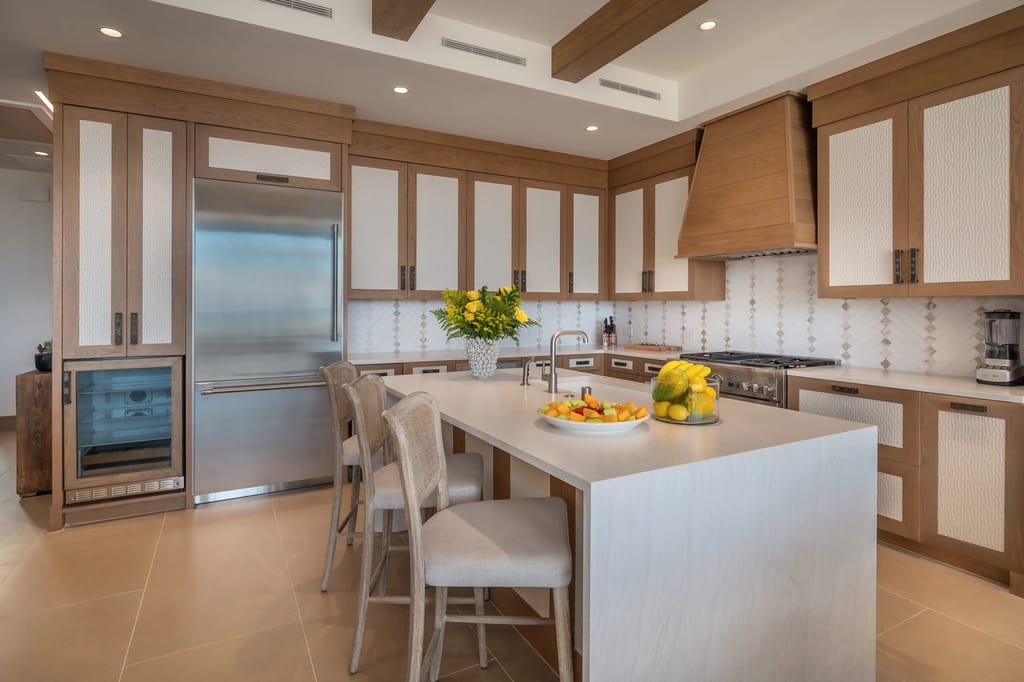 A modern kitchen with a large island, stainless steel appliances, and wood cabinets.
