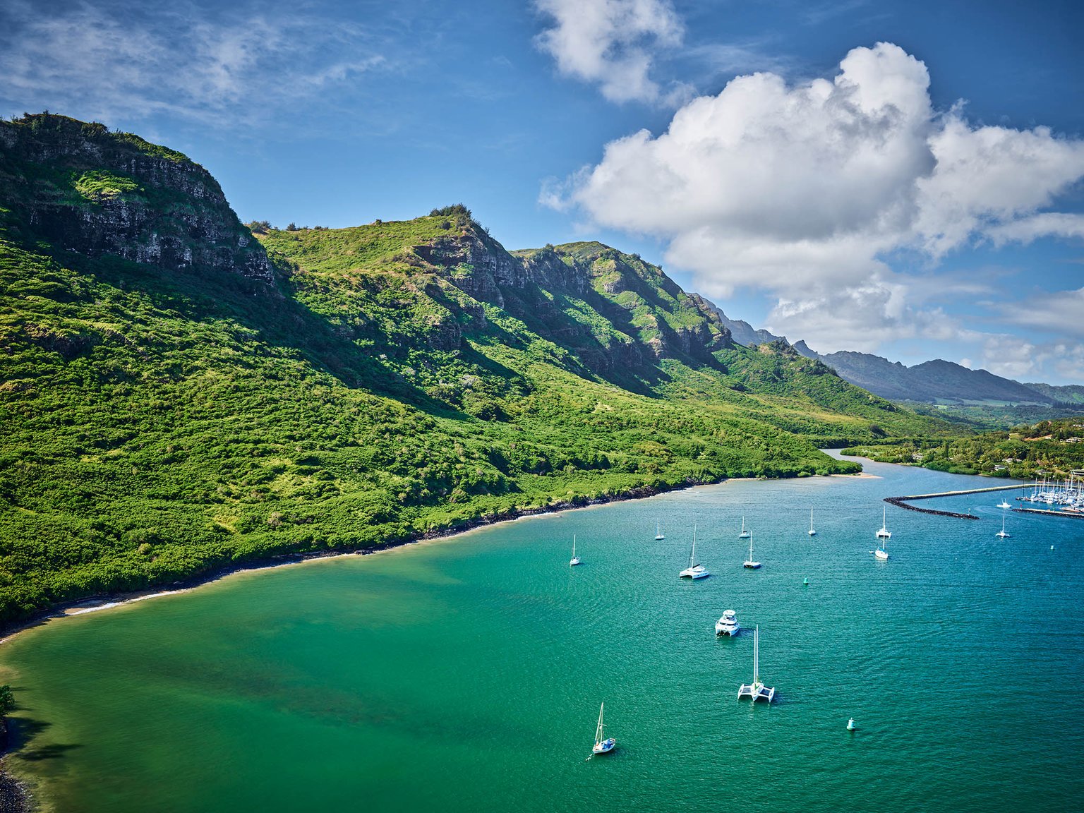 Aerial view of a bay with boats and mountains