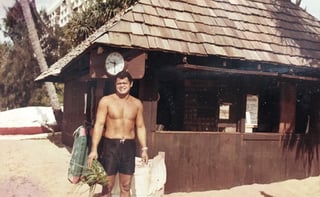 Leleo Kinimaka, master woodworker, stands in front of a building