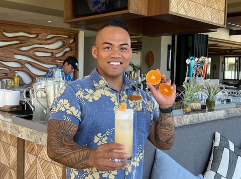 Mandarin Gin Fizz cocktail held by Bartender Jay