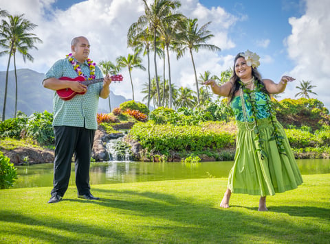 traditional polynesian entertainers perform; a man with a ukelele and a female hula dancer