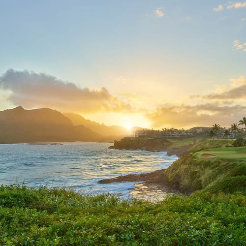 Sunsetting behind Timbers Kauai and the Hāʻupu Mountains on Kauai within the Hokuala Hawaii resort, as viewed from the 14th tee of the Ocean Course at Hokuala